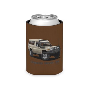 May include: A brown can cooler featuring a white Toyota Land Cruiser with a roof top tent. The text "Legends Never Die" is printed on the cooler.
