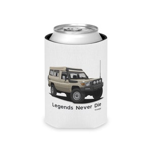May include: White can cooler featuring a beige Toyota Land Cruiser with a roof top tent. The text "Legends Never Die" and "Troopy" is printed on the cooler.