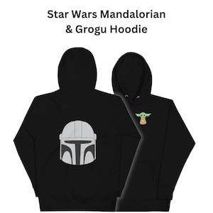May include: Black hoodie with a gray Mandalorian helmet on the back and a green Grogu character on the front. "Star Wars Mandalorian & Grogu Hoodie" is written above the image.