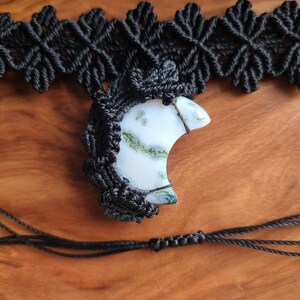 May include: A black macrame necklace with a crescent moon shaped green and white agate pendant.