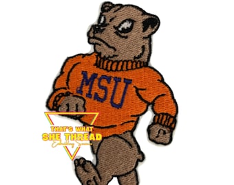 Può includere: Una toppa ricamata con un bulldog dei cartoni animati che indossa un maglione arancione con le lettere "MSU" in viola. Il bulldog sta camminando e ha un'espressione arrabbiata.