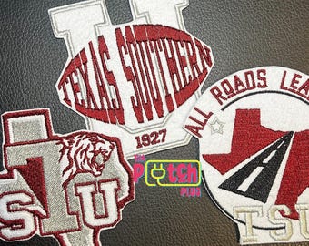 Può includere: Tre toppe ricamate a tema Texas Southern University. Una toppa mostra una grande U con la scritta Texas Southern 1927. Un'altra ha la forma del Texas con una testa di tigre e le lettere TSU. La terza è una toppa circolare con la grafica di una strada.