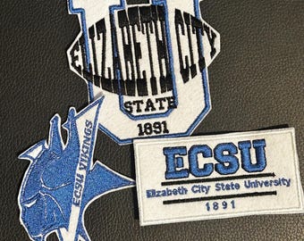 Può includere: Tre toppe ricamate con il marchio della Elizabeth City State University. Una toppa è una grande U bianca con il testo nero Elizabeth City State 1891. Un'altra è un logo con mascotte vichinga blu con il testo ECSU VIKINGS. Una toppa rettangolare riporta ECSU Elizabeth City State University 1891.