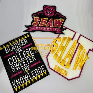 May include: Three embroidered patches featuring the Shaw University logo. The first patch is black with white text that reads "Blacker the College Sweeter the Knowledge". The second patch is black with a pink bear and the text "Shaw University". The third patch is white with a red border and the text "Shaw 1865" in gold.