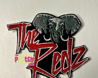 Può includere: Toppa ricamata rossa e bianca su sfondo nero. La toppa presenta un elefante stilizzato con il testo "The Redz" in rosso e bianco.