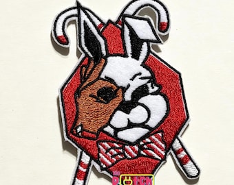 Può includere: Toppa ricamata con un design diviso di una renna e un coniglio, con un papillon a righe rosse e bianche. La toppa è circondata da un ottagono rosso e accenti di bastoncini di zucchero. Il testo "The Patch Plug" è visibile.