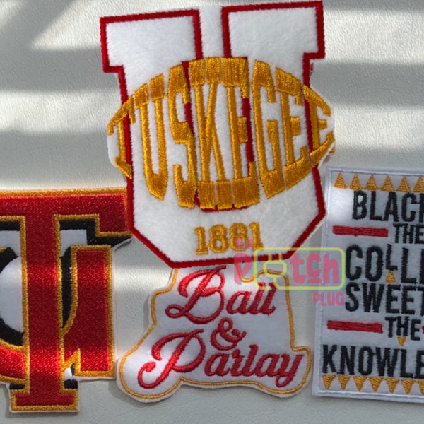 Op de afbeelding: Vier geborduurde patches in een rood, wit en gouden kleurenschema. De patches bevatten de woorden "Tuskegee 1881", "Ball & Parlay" en "Blacker the College Sweeter the Knowledge".