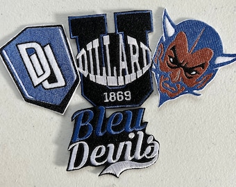 Può includere: Quattro toppe ricamate, due blu, una bianca e nera e una marrone e blu. Le toppe blu presentano le lettere "DJ" e "U", la toppa bianca e nera dice "Bleu Devils" e la toppa marrone e blu presenta un viso di diavolo. La toppa "U" dice anche "Dillard 1869".