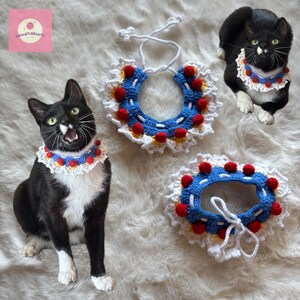 May include: Three crochet cat collars in a Snow White theme. The collars are white with a blue center, red pom-poms, and yellow accents. Two black and white cats are wearing the collars. The image includes the text "HannaTreasures".