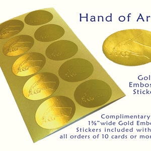 May include: Gold embossed oval stickers with a hand holding a pen design. The text "Hand of Art" and "Gold Embossed Stickers" are visible. Each sticker is approximately 3.5 cm wide.