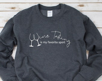 May include: A dark gray sweatshirt with the text "Wine Tasting is my favorite sport" and two wine glass silhouettes.