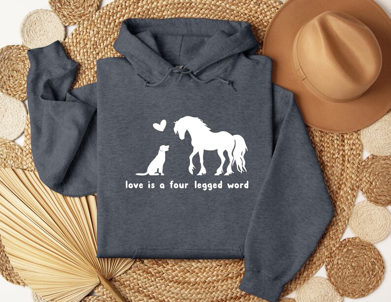 May include: A dark grey hoodie with a white graphic of a horse and dog with a heart above them. The text "love is a four legged word" is below the graphic.