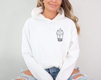 May include: White hoodie with a black graphic of a boba tea drink with a cat face design. The sweatshirt has a drawstring hood and long sleeves. The design is on the left chest area.