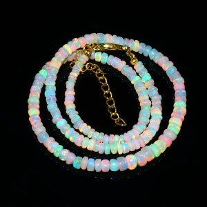 Puede incluir: Un collar de m&uacute;ltiples hilos hecho de cuentas de &oacute;palo iridiscente. El collar est&aacute; hecho de peque&ntilde;as cuentas redondas que est&aacute;n enhebradas en una cadena de oro. Las cuentas son de varios colores, incluyendo blanco, rosa y azul.