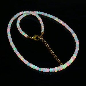 Puede incluir: Un delicado collar hecho de cuentas de &oacute;palo iridiscente con un cierre y una cadena extensora de oro.