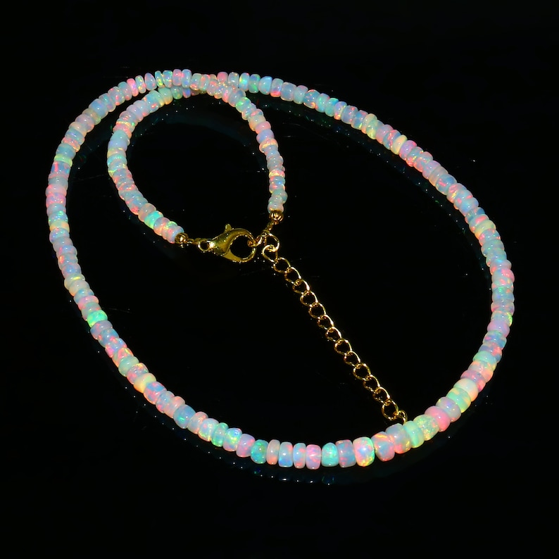 Puede incluir: Un delicado collar hecho de cuentas de &oacute;palo iridiscente con un cierre y una cadena extensora de oro.