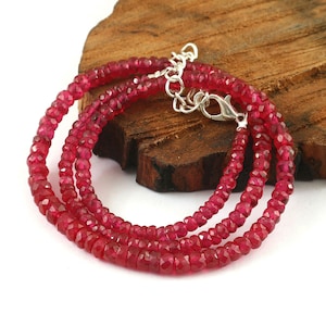 以下が含まれることがあります： 小さなファセットカットのルビービーズで作られたネックレス。ネックレスは2連で、シルバーの留め具が付いています。