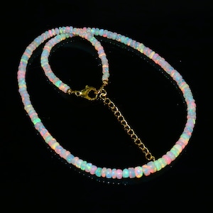 Puede incluir: Un delicado collar hecho de cuentas de &oacute;palo iridiscente con un cierre y una cadena extensora de oro.