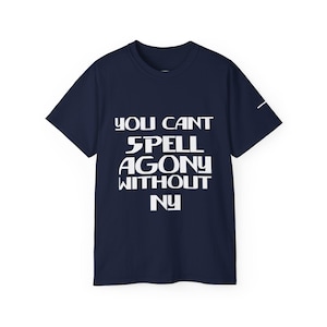 Könnte beinhalten: Marineblaues T-Shirt mit dem weißen Text "YOU CANT SPELL AGONY WITHOUT NY". Das Shirt hat kurze Ärmel und einen Rundhalsausschnitt. Auf dem rechten Ärmel ist eine weiße Linie zu sehen.