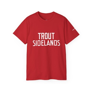 Peut inclure: T-shirt rouge avec l'inscription blanche "TROUT SIDELANDS". Le t-shirt à manches courtes a un col rond et une ligne blanche sur la manche droite.