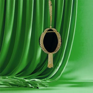 May include: A black velvet clutch bag with a gold chain strap and a gold tassel. The bag is decorated with gold beads and rhinestones.