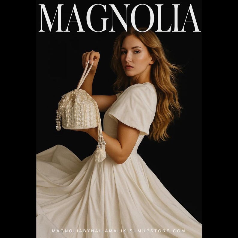 May include: A woman in a white dress holds a cream-coloured beaded purse with a tassel. The word "MAGNOLIA" is at the top of the image. The website address MAGNOLIABYNAILAMALIK.SUMUPSTORE.COM is at the bottom.