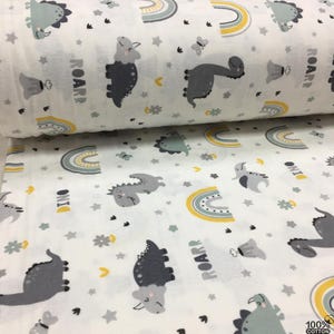 May include: White cotton fabric printed with a repeating pattern of gray dinosaurs, yellow and gray rainbows, stars, and flowers. The word "ROARR" is printed in gray. The fabric is 100% cotton.