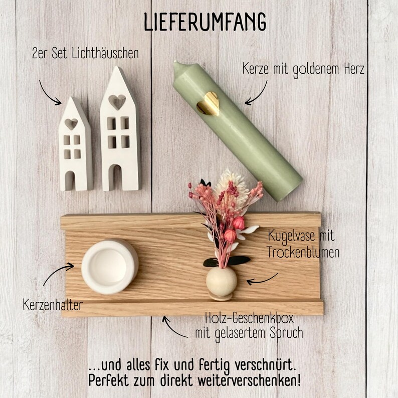 Peut inclure: Une bo&icirc;te cadeau en bois contenant une bougie, deux petites maisons, un vase avec des fleurs s&eacute;ch&eacute;es et un bougeoir. La bo&icirc;te est &eacute;tiquet&eacute;e "LIEFERUMFANG" et comprend le texte "... und alles fix und fertig verschn&uuml;rt. Perfekt zum direkt weiterverschenken!"