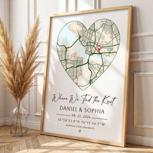 Puede incluir: Un cuadro decorativo con un mapa en forma de corazón y un marcador de ubicación rojo. El texto dice: Where We Tied the Knot, DANIEL & SOPHIA, 08. 22. 2026, 36°50'53.9"N 76°15'46.7"W, NORFOLK STATE UNIVERSITY, y un pequeño símbolo de corazón.