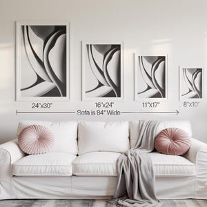 May include: Four framed abstract art prints in varying sizes, displayed above a white sofa. The prints are in black and white, with dimensions of 24"x30", 16"x24", 11"x17", and 8"x10". The sofa is 84 inches wide.