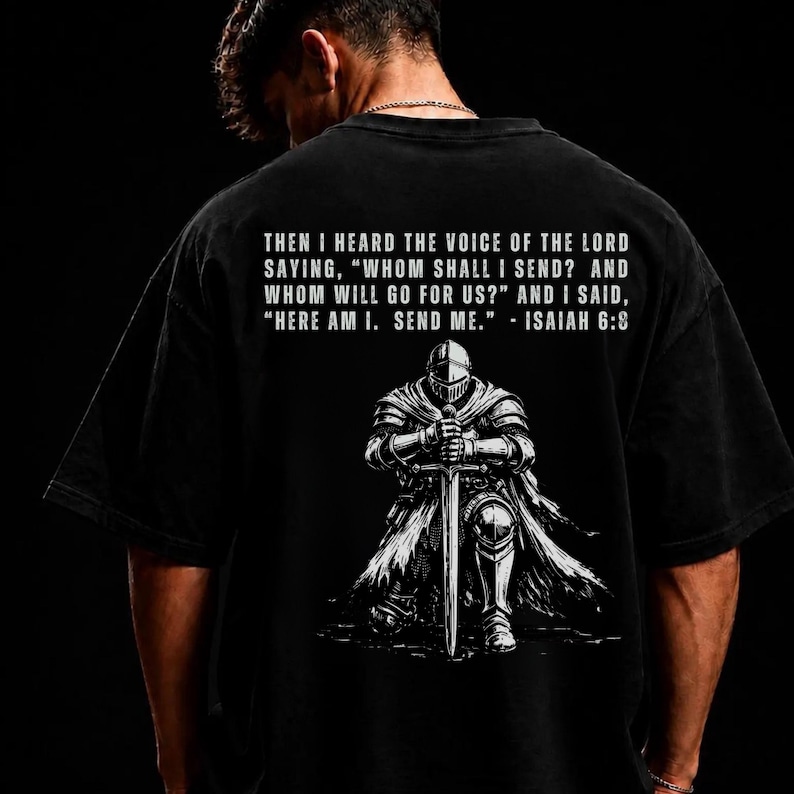 May include: A black t-shirt featuring a white graphic of a knight kneeling with a sword. Above the knight, the text reads: THEN I HEARD THE VOICE OF THE LORD SAYING, "WHOM SHALL I SEND? AND WHOM WILL GO FOR US?" AND I SAID, "HERE AM I. SEND ME." - ISAIAH 6:8
