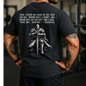 May include: A black short-sleeved t-shirt featuring a graphic of a knight in armor kneeling with a sword. Above the knight, the text reads: THEN I HEARD THE VOICE OF THE LORD SAYING, "WHOM SHALL I SEND? AND WHOM WILL GO FOR US?" AND I SAID, "HERE AM I. SEND ME." - ISAIAH 6:8.