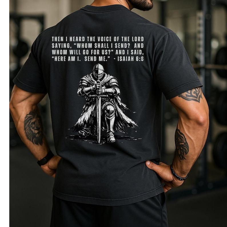 May include: A black short-sleeved t-shirt featuring a graphic of a knight in armor kneeling with a sword. Above the knight, the text reads: THEN I HEARD THE VOICE OF THE LORD SAYING, "WHOM SHALL I SEND? AND WHOM WILL GO FOR US?" AND I SAID, "HERE AM I. SEND ME." - ISAIAH 6:8.