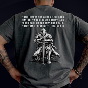 May include: A charcoal gray t-shirt featuring a white graphic of a knight in armor kneeling and holding a sword. Above the knight, the text reads: THEN I HEARD THE VOICE OF THE LORD SAYING, WHOM SHALL I SEND? AND WHOM WILL GO FOR US? AND I SAID, HERE AM I. SEND ME. - ISAIAH 6:8.