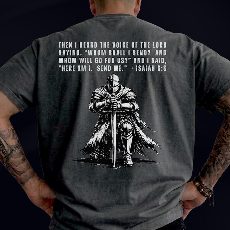 May include: A charcoal gray t-shirt featuring a white graphic of a knight in armor kneeling and holding a sword. Above the knight, the text reads: THEN I HEARD THE VOICE OF THE LORD SAYING, WHOM SHALL I SEND? AND WHOM WILL GO FOR US? AND I SAID, HERE AM I. SEND ME. - ISAIAH 6:8.