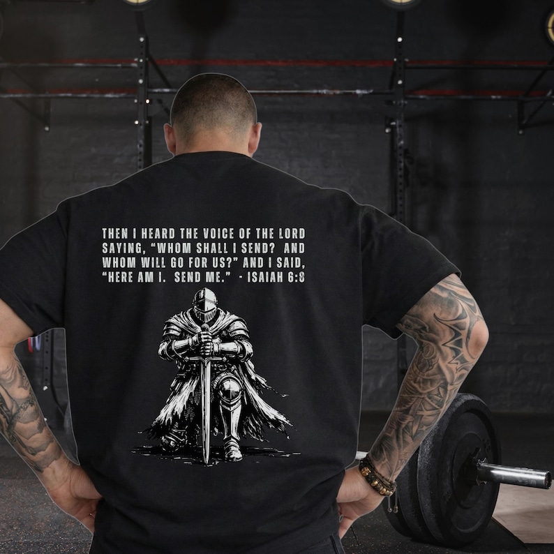 May include: A black t-shirt featuring a white graphic of a knight kneeling with a sword. Above the knight, the text reads: THEN I HEARD THE VOICE OF THE LORD SAYING, "WHOM SHALL I SEND? AND WHOM WILL GO FOR US?" AND I SAID, "HERE AM I. SEND ME." - ISAIAH 6:8