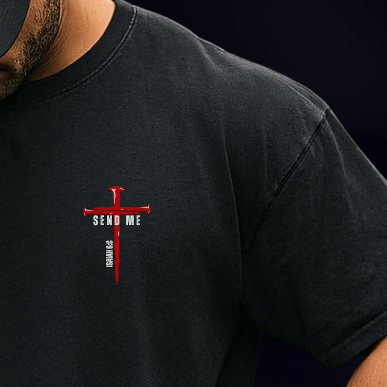 May include: A black t-shirt featuring a graphic on the chest. The design consists of a red cross made of nails with the white text SEND ME across the horizontal bar and the white text ISAIAH 6:8 printed vertically along the bottom of the cross.