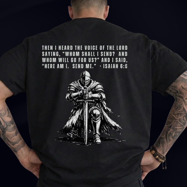 May include: A black t-shirt featuring a white graphic of a knight in armor kneeling and holding a sword. Above the knight, the text reads: THEN I HEARD THE VOICE OF THE LORD SAYING, "WHOM SHALL I SEND? AND WHOM WILL GO FOR US?" AND I SAID, "HERE AM I. SEND ME." - ISAIAH 6:8