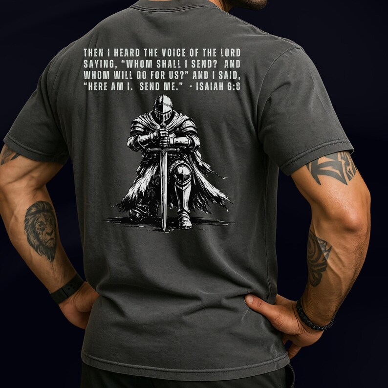 May include: A charcoal gray t-shirt featuring a white graphic of a knight kneeling with a sword. Above the knight, the text reads: THEN I HEARD THE VOICE OF THE LORD SAYING, "WHOM SHALL I SEND? AND WHOM WILL GO FOR US?" AND I SAID, "HERE AM I. SEND ME." - ISAIAH 6:8