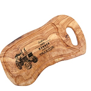 Servierbrett aus Olivenholz mit Lasergravur eines Traktors und dem Text "Thomas Echte Männer fahren Traktor" auf weißem Grund.