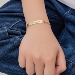 Könnte beinhalten: Ein goldenes Kettenarmband mit einem rechteckigen Namensschild, auf dem "Daniel" steht.