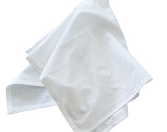 May include: A white cotton dish towel folded and crumpled, ready for use.
