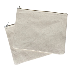 May include: Two beige canvas zipper pouches with silver zippers. The pouches are stacked on top of each other.