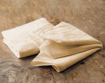 May include: Two off-white cotton dish towels folded on a wooden surface.