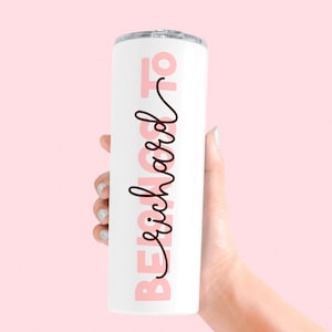 May include: White stainless steel tumbler with a pink and black design that says "Beach Mode On".