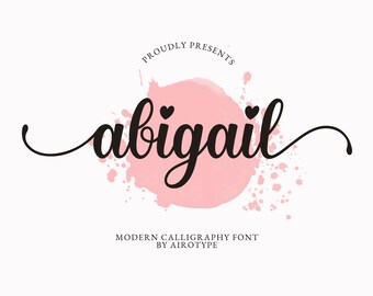 以下が含まれることがあります： 黒い筆記体のカリグラフィーフォントで書かれたabigailという名前と、文字の上の2つの小さなハートが特徴のデジタルグラフィック。テキストは淡いピンクの水彩画のしぶきの上に中央揃えされています。テキストにはPROUDLY PRESENTSとMODERN CALLIGRAPHY FONT BY AIROTYPEと書かれています。