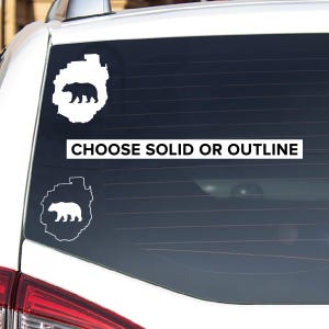 May include: White car window decal with a bear silhouette inside a state outline. The text "CHOOSE SOLID OR OUTLINE" is below the decal.