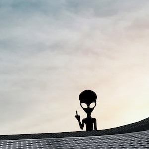 Puede incluir: Silueta de un extraterrestre gris haciendo el dedo medio contra un cielo nublado.