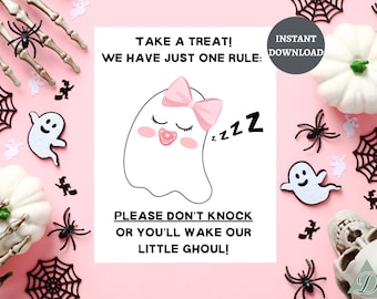 Puede incluir: Un letrero imprimible con temática de Halloween con un fantasma durmiente con un lazo rosa y un chupete. El letrero dice: "¡Toma un dulce! Solo tenemos una regla: ¡No llames a la puerta o despertarás a nuestro pequeño demonio!" con arañas y calabazas.