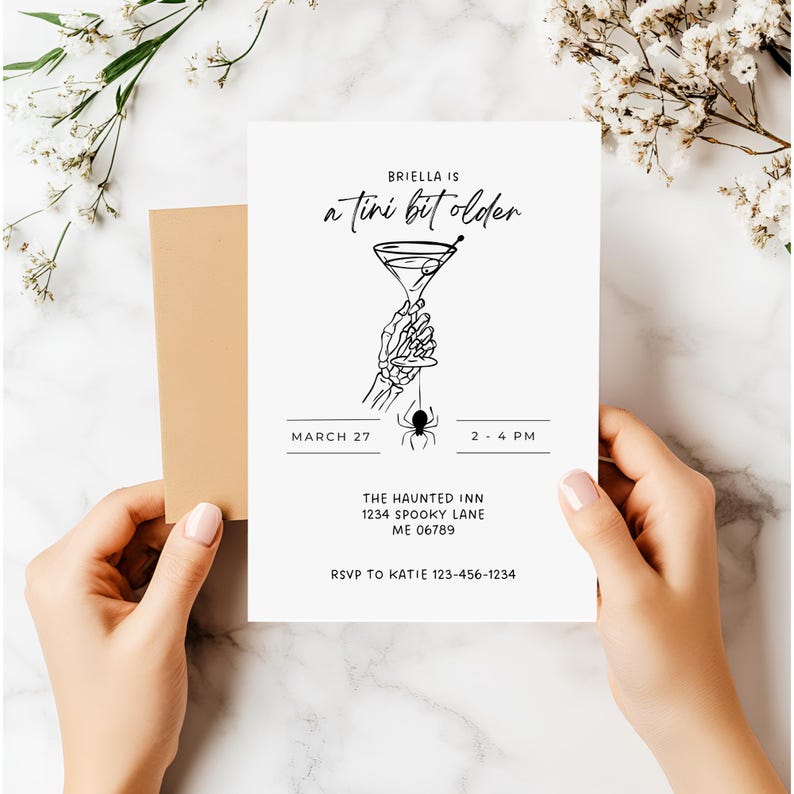 K&ouml;nnte beinhalten: Eine wei&szlig;e Einladungskarte mit schwarzem Text und einem beigefarbenen Umschlag. Auf der Karte steht "Briella is a tini bit older" mit einer Martini-Glas-Grafik, die von einer Skeletthand gehalten wird. Das Datum ist der 27. M&auml;rz, 14-16 Uhr.